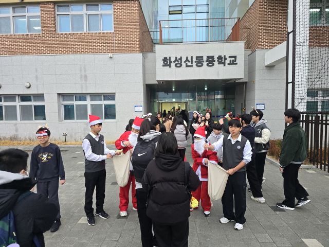화성신동중학교 학생들이 등교하는 학우들에게 성탄 선물을 나눠주고 있다. 신동중학교 제공