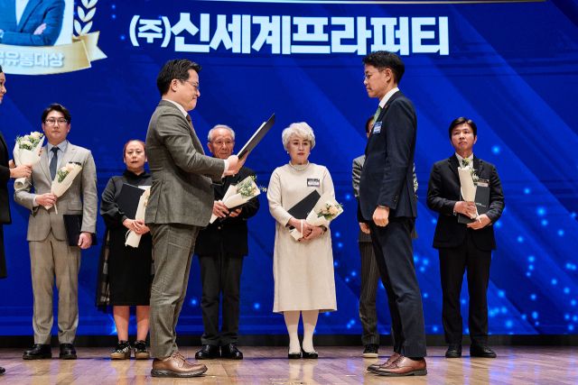 신세계프라퍼티가 지난 26일 대한상공회의소에서 열린 ‘제30회 한국유통대상’ 시상식에서 유통산업 상생·협력 문화확산 유공 부문 산업통상부장관 표창을 수상했다. 신동우 신세계프라퍼티 지원본부장(앞줄 오른쪽)이 표창을 수상하고 있다. 신세계프라퍼티 제공