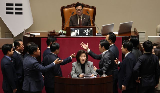 지난 9일 국회 본회의에서 국민의힘 나경원 의원이 '가맹사업거래의 공정화에 관한 법률 일부개정법률안'에 대해 무제한 토론하는 가운데 여야 의원들이 발언대에서 신경전하는 모습. 연합뉴스