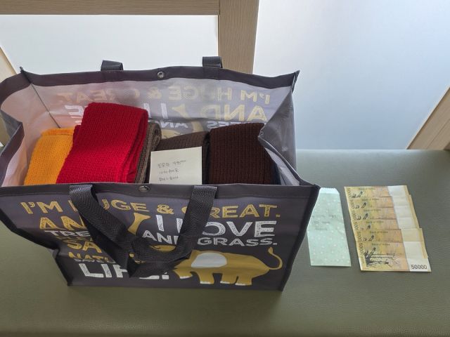 크리스마스 이브인 24일 광주시 경안동 민원실 의자에 익명의 기부자가 민원실 의자위에 놓고 간 목도리와 현금. 광주시 제공