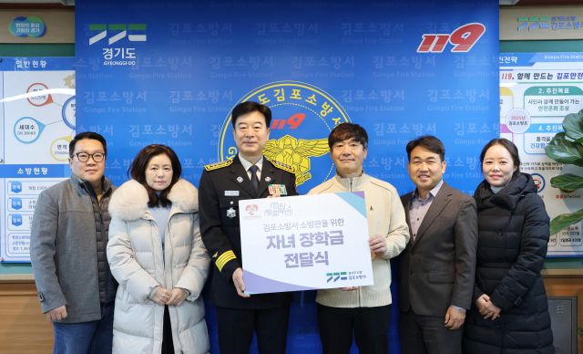 ‘징검다리봉사단’ 회원들이 유해공 김포소방서장(가운데)에게 장학금을 전달하며 기념사진을 촬영하고 있다. 김포소방서 제공