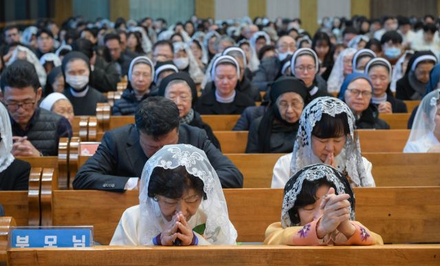 후보들의 가족들과 참석자들이 기도하고 있다.