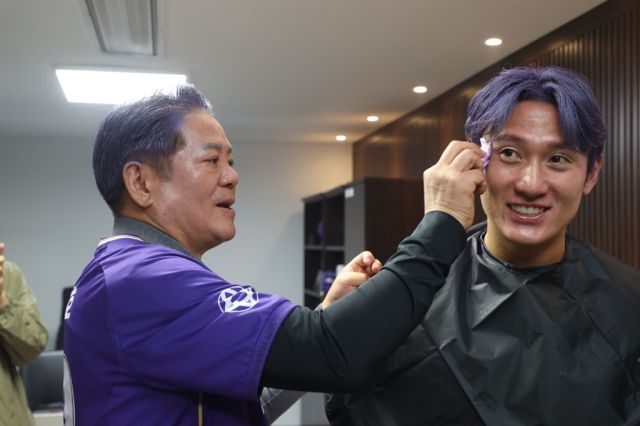 최대호 안양시장(왼쪽)이 FC안양 단장실에서 함께 머리를 보라색으로 염색한 김동진 FC안양 선수(오른쪽)의 얼굴을 닦아주고 있다. 안양시 제공.