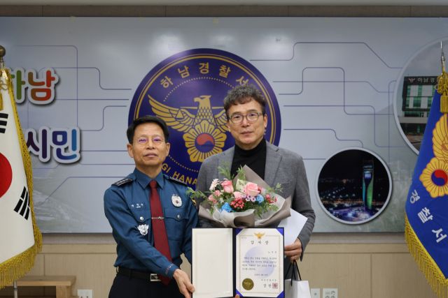 자신의 차량을 이용, 2차 사고를 방지한 하남 시민 A씨(오른쪽)에게 장한주 하남경찰서장은 감사장과 포상금을 전달했다. 하남경찰서 제공