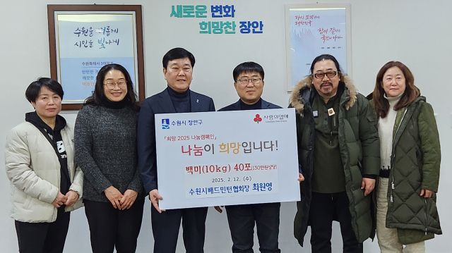 최원영 수원시배드민턴협회장(오른쪽 3번째)이 취임식 때 축하 화환대신 받은 백미를 이상수 수원 장안구청장에게 전달하고 있다.수원시배드민턴협회 제공