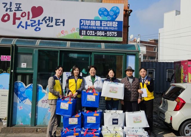 김포아이사랑센터 자원봉사자들이 새학기 책가방과 학용품 세트를 들고 기념사진을 촬영하고 있다. 김포아이사랑센터 제공