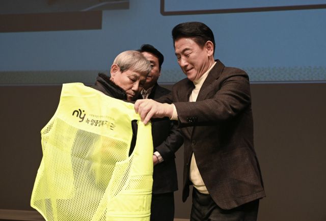 김동근 의정부시장이 지난 13일 오후 ‘노인일자리사업 통합발대식’에서 일자리사업 참여 노인에게 조끼를 입혀 주고 있다. 의정부시 제공.