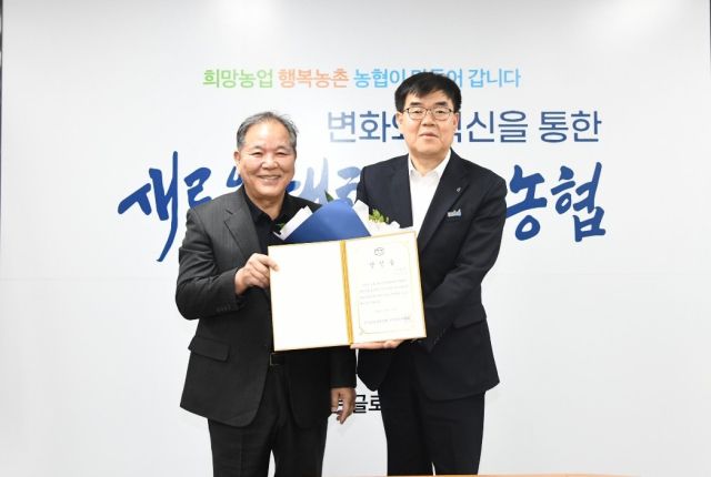 박동우(왼쪽) 경기도레슬링협회 선거관리위원장이 엄범식 5대 회장 당선인에게 당선증을 전달한 뒤 기념촬영을 하고 있다.