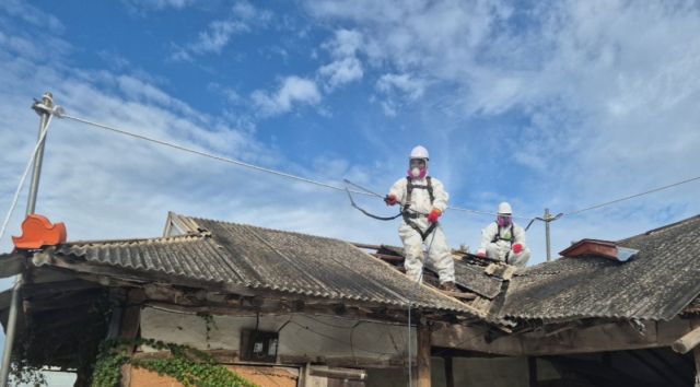 인천 중구청 관계자들이 슬레이트로 만든 지붕을 처리하고 있다. 중구청 제공