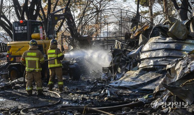 24일 오후 화재가 발생한 광명시 광명동 한 창고용 비닐하우스에서 소방대원들이 잔불 정리 및 현장 점검을 하고 있다. 화재 초기에는 불이 주변 야산으로 번질 위험이 있어 대응 1단계가 발령됐으며, 소방당국은 장비 33대와 인력 83명을 투입하고, 헬기와 드론을 동원해 산불 확산을 막았다. 윤원규기자