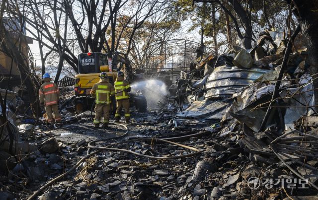 24일 오후 화재가 발생한 광명시 광명동 한 창고용 비닐하우스에서 소방대원들이 잔불 정리 및 현장 점검을 하고 있다. 화재 초기에는 불이 주변 야산으로 번질 위험이 있어 대응 1단계가 발령됐으며, 소방당국은 장비 33대와 인력 83명을 투입하고, 헬기와 드론을 동원해 산불 확산을 막았다. 윤원규기자