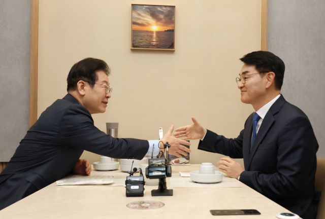 더불어민주당 이재명 대표가 21일 서울 여의도의 한 식당에서 오찬회동 중 박용진 전 의원과 악수하고 있다.연합뉴스