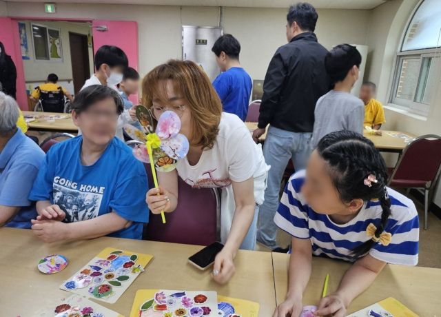윤미정 단장이 장애인들과 함께 바람개비를 만들고 있다. 본인 제공
