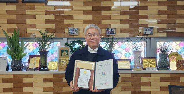 배인식 온해피 회장이 교육부의 교육기부 우수기관 인증패를 들고 기념촬영을 하고 있다. 온해피 제공