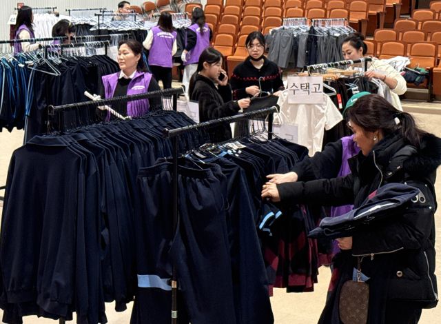 8일 구리시청 대강당에서 열린 ‘구리알뜰교복은행' 집중 판매행사에서 학부모와 학생들이 교복을 고르고 있다. 구리지역 16개 중·고등학교 졸업생들이 기증한 교복 5천600점은 세탁과 수선을 거쳐 5천원 이하의 저렴한 가격으로 판매됐다.조주현기자