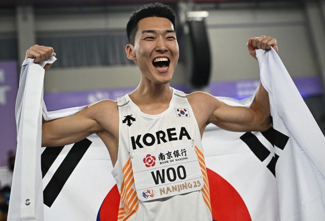 21일 중국 장쑤성 난징의 유스올림픽스포츠파크에서 벌어진 2025 세계실내육상선수권대회 남자 높이뛰기서 우승한 우상혁이 태극기를 들고 환호하고 있다.로이터=연합뉴스