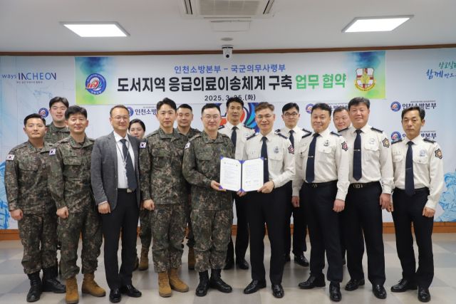 이상호 국군의무사령관과 임원섭 인천소방본부장이 25일 업무협약을 한 뒤 참석자들과 함께 기념 촬영을 하고 있다. 인천소방본부제공