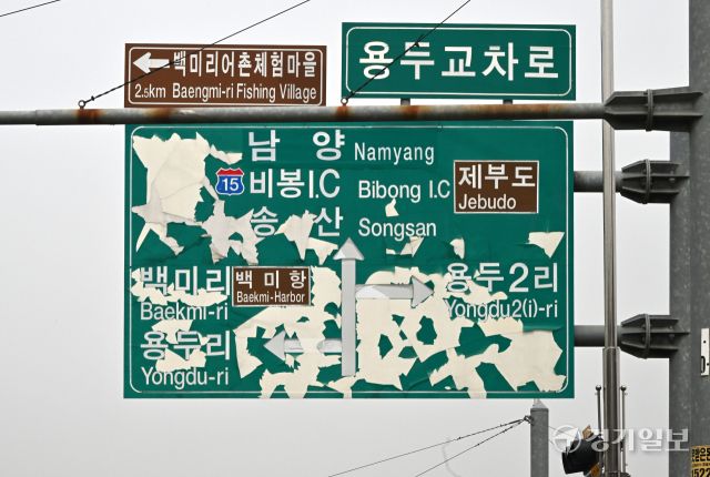 25일 화성특례시 서신면 용두교차로에 설치된 도로안내 표지판이 내용을 알아볼 수 없을 만큼 훼손된 채 수개월째 방치돼 있다. 김시범기자