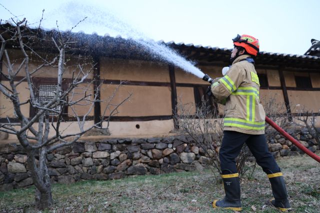 25일 경북 안동 하회마을에서 소방관이 산불에 대비해 물을 뿌리고 있다.연합뉴스