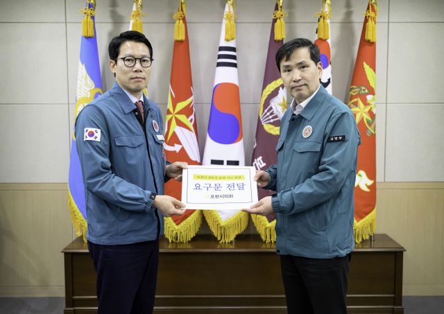 임종훈 포천시의회 의장(왼쪽)이 김선호 국방부 장관 직무대행에게 요구문을 전달하고 있다. 포천시의회 제공