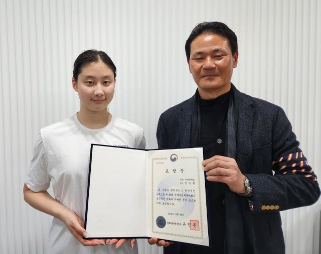 김범준 경기도수영연맹 회장(오른쪽)이 수영 유망주 김승원(용인 구성중)에게 유인촌 문화체육관광부장관 표창장을 전수하고 있다.경기도수영연맹 제공