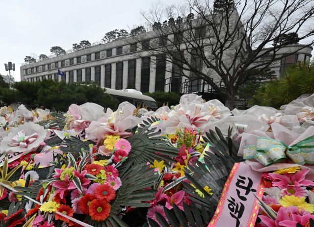 윤석열 대통령 탄핵 심판 선고에 대한 헌법재판소의 침묵이 길어지면서 정치권 뿐만 아니라 사회 각계각층의 헌재를 향한 압박이 거세지고 있다. 30일 오후 헌법재판소 담장에 윤 대통령 탄핵 찬반 화환들이 놓여 있다. 조주현기자