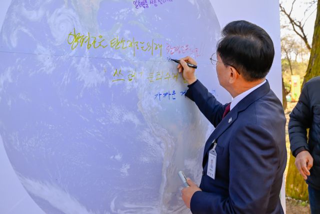 전진선 양평군수가 기후변화대응·탄소중립 실천을 위해 ‘탄소제로를 위해 환경교육도시로’ 라는 문구를 지구그림에 적고 있다. 양평군 제공