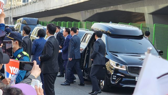 윤 전 대통령이 관저를 퇴거하던 중 차량에서 내려 지지자들에게 인사를 건네기 위해 이동하고 있다. 한준호기자