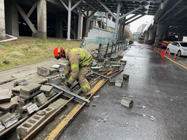 13일 오전 10시30분께 수원역 환승센터에서 담장이 무너져 소방대원이 사고 현장을 수습하고 있다. 경기도소방재난본부 제공