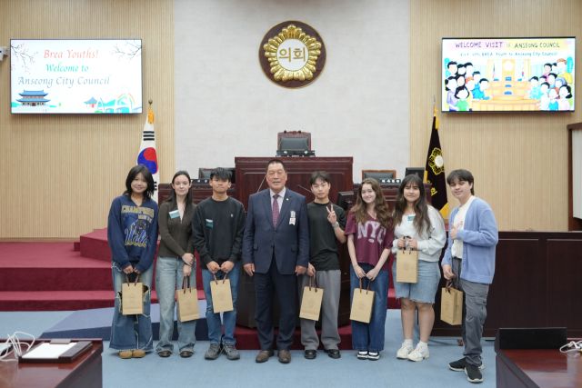 안성시의회 안정렬 의장과 미국 브레아시 청소년 7명이 시의회 본회의장에서 기념 촬영을 하고 있다. 안성시의회 제공