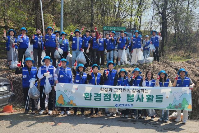 한세대학교 학생과 교직원들이 학교 인근 도로와 등산로 등에서 환경정화 활동을 펼치며 기념촬영을 하고 있다. 한세대학교 제공