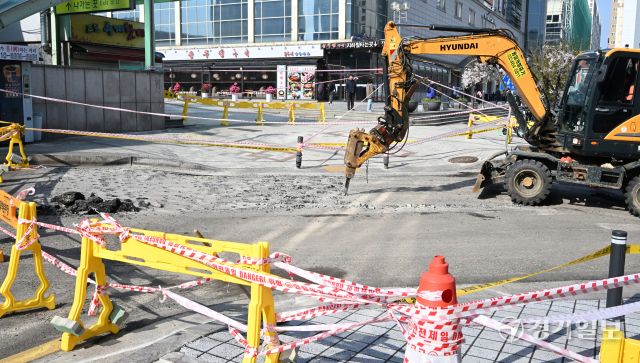 지난 15일 오후 8시께 가로 5m, 깊이 10cm 규모의 땅꺼짐 현상이 발생한 인천 부평역 앞 인근 도로에서 16일 오전 작업자가 도로 복구작업을 하고 있다. 인천시는 지하통로 건설 과정에서 상층부 흙이 얼었다가 날이 풀려 녹으면서 일부 침하된 것으로 추정하고 있다.조병석기자