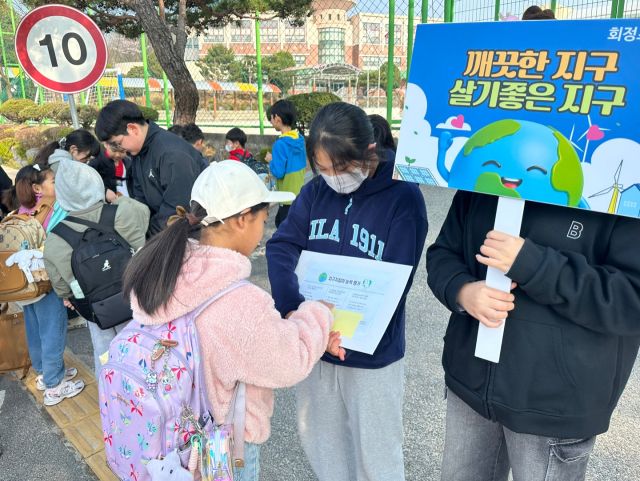 회정초등학교 3~6학년 학생자치회 임원들이 등교하는 학생들을 대상으로 지구사랑 캠페인을 펼치고 있다. 회정초교 제공