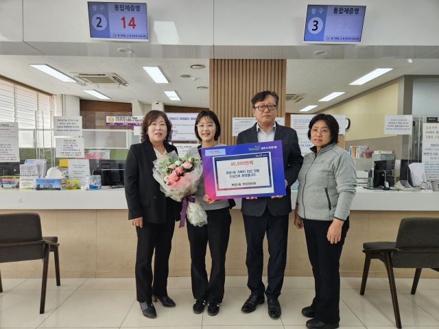 김동희 옥정1동장(오른쪽 두번째)이 4만번째 주민등록한 주민에게 꽃다발을 선물하고 기념사진을 찍고 있다. 양주시 제공