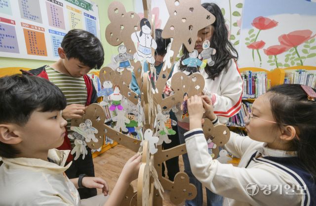 세계 책의 날을 하루 앞둔 22일 오전 수원특례시 영통구 효동초등학교 도서관에서 학생들이 본인의 추천 도서를 적어 독서나무에 걸고 있다. 윤원규기자