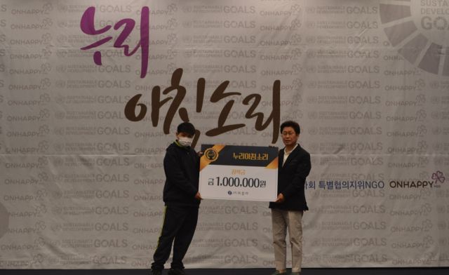 온해피가 최근 연 2025년 첫 누리아침소리 포럼에서 곽노희 ㈜토일러 회장이 강종현 초은중학교 학생에게 특별 장학금을 전달하고 있다. 온해피 제공