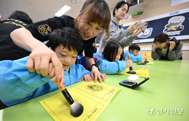22일 오전 인천 남동구 인천경찰청에서 진행된 ‘KCSI 과학수사 체험교실’에 참가한 어린이들이 지문 채취 체험을 하고 있다.조병석기자