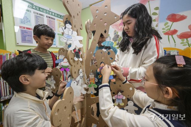 세계 책의 날을 하루 앞둔 22일 오전 수원특례시 영통구 효동초등학교 도서관에서 학생들이 본인의 추천 도서를 적어 독서나무에 걸고 있다. 윤원규기자