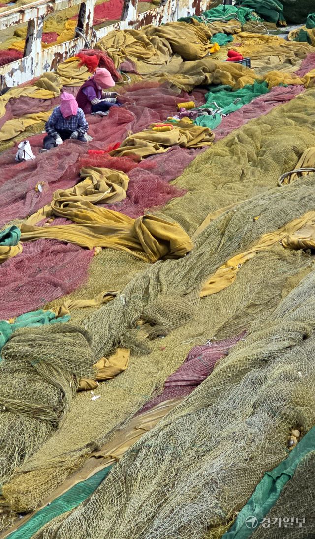 완연한 봄 날씨를 보인 23일 인천 중구 북성포구에서 어민들이 출어를 위해 배 위에 그물을 펼쳐 손질을 하고 있다.조병석기자