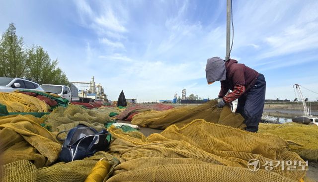 완연한 봄 날씨를 보인 23일 인천 중구 북성포구에서 어민들이 출어를 위해 배 위에 그물을 펼쳐 손질을 하고 있다.조병석기자