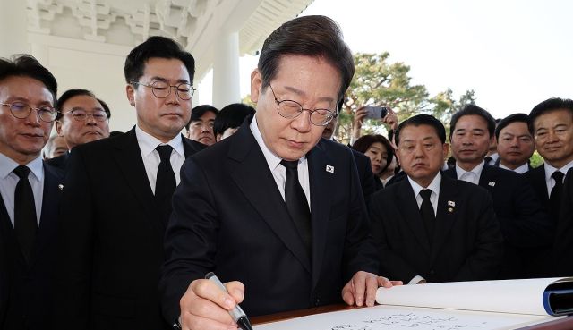 더불어민주당 이재명 대선 후보가 28일 동작구 국립서울현충원 참배를 마친 후 방명록 글을 작성하고 있다. 연합뉴스