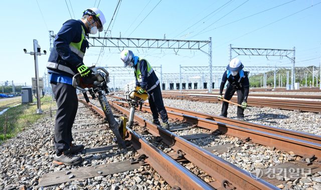 29일 인천 계양구 인천교통공사 귤현차량사업소 기지 구내에서 토목파트 직원들이 자갈도상 작업에 매진하고 있다. 자갈도상 작업은 느슨해진 자갈을 다짐기계로 단단하게 다짐하는 것으로 궤도의 변형을 방지하고 열차하중을 지반에 고르게 전달되도록 하는 작업이다. 조병석기자