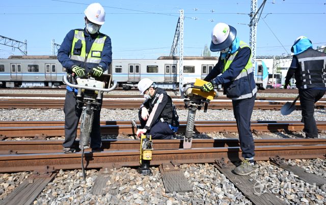 29일 인천 계양구 인천교통공사 귤현차량사업소 기지 구내에서 토목파트 직원들이 자갈도상 작업에 매진하고 있다. 자갈도상 작업은 느슨해진 자갈을 다짐기계로 단단하게 다짐하는 것으로 궤도의 변형을 방지하고 열차하중을 지반에 고르게 전달되도록 하는 작업이다. 조병석기자