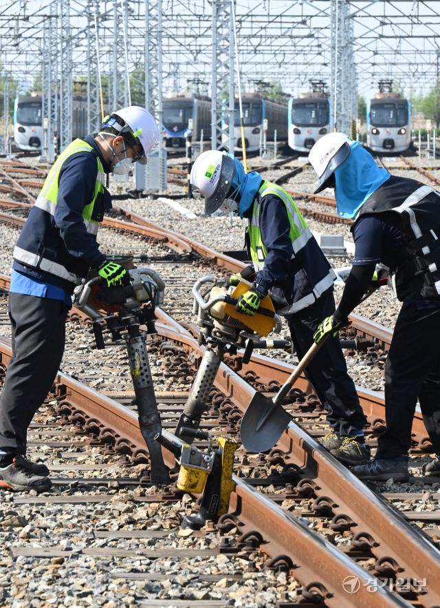 29일 인천 계양구 인천교통공사 귤현차량사업소 기지 구내에서 토목파트 직원들이 자갈도상 작업에 매진하고 있다. 자갈도상 작업은 느슨해진 자갈을 다짐기계로 단단하게 다짐하는 것으로 궤도의 변형을 방지하고 열차하중을 지반에 고르게 전달되도록 하는 작업이다. 조병석기자