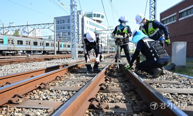 29일 인천 계양구 인천교통공사 귤현차량사업소 기지 구내에서 토목파트 직원들이 자갈도상 작업에 매진하고 있다. 자갈도상 작업은 느슨해진 자갈을 다짐기계로 단단하게 다짐하는 것으로 궤도의 변형을 방지하고 열차하중을 지반에 고르게 전달되도록 하는 작업이다. 조병석기자