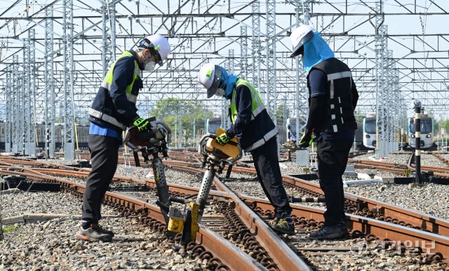 29일 인천 계양구 인천교통공사 귤현차량사업소 기지 구내에서 토목파트 직원들이 자갈도상 작업에 매진하고 있다. 자갈도상 작업은 느슨해진 자갈을 다짐기계로 단단하게 다짐하는 것으로 궤도의 변형을 방지하고 열차하중을 지반에 고르게 전달되도록 하는 작업이다. 조병석기자