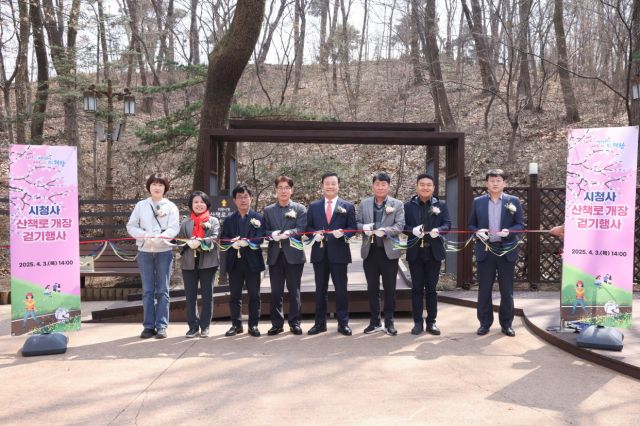 김성제 의왕시장과 김학기 시의회의장을 비롯한 시의원 등이 3일 시청 외곽 산책로 개장식에서 테이프를 자르고 있다. 의왕시 제공
