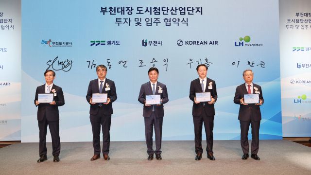 조용익 부천시장(가운데)을 비롯한 부천도시공사-경기도-부천시-대한항공-한국토지주택공사(LH) 등 5개 기관 대표자들이 서명을 마친 후 협약서가 담긴 태블릿을 들고 기념 촬영을 하고 있다. 부천시 제공