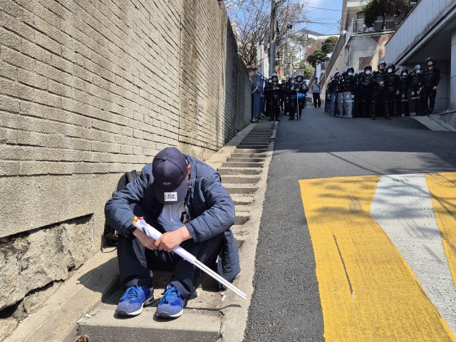 4일 오전 11시40분께 윤 대통령에 대한 탄핵이 인용된 이후 탄핵 반대 집회 참석자가 망연자실한 채 길바닥에 앉아 있다. 김한울기자