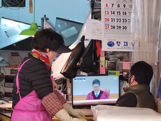 인천 부평구 부평깡시장의 상인들이 TV로 윤석열 대통령의 탄핵심판을 보고 있다. 황남건기자